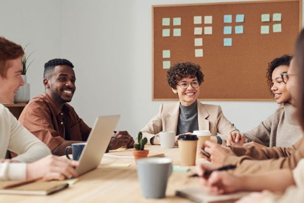 Un groupe de travail est assis ensemble dans un bureau.