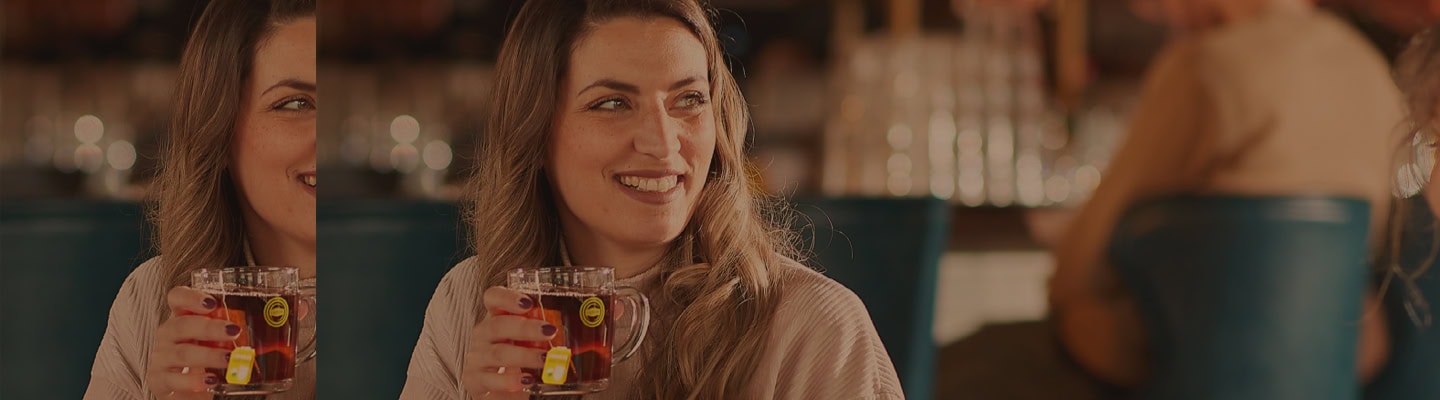 Deux femmes sont assises Ă une table avec des boissons.